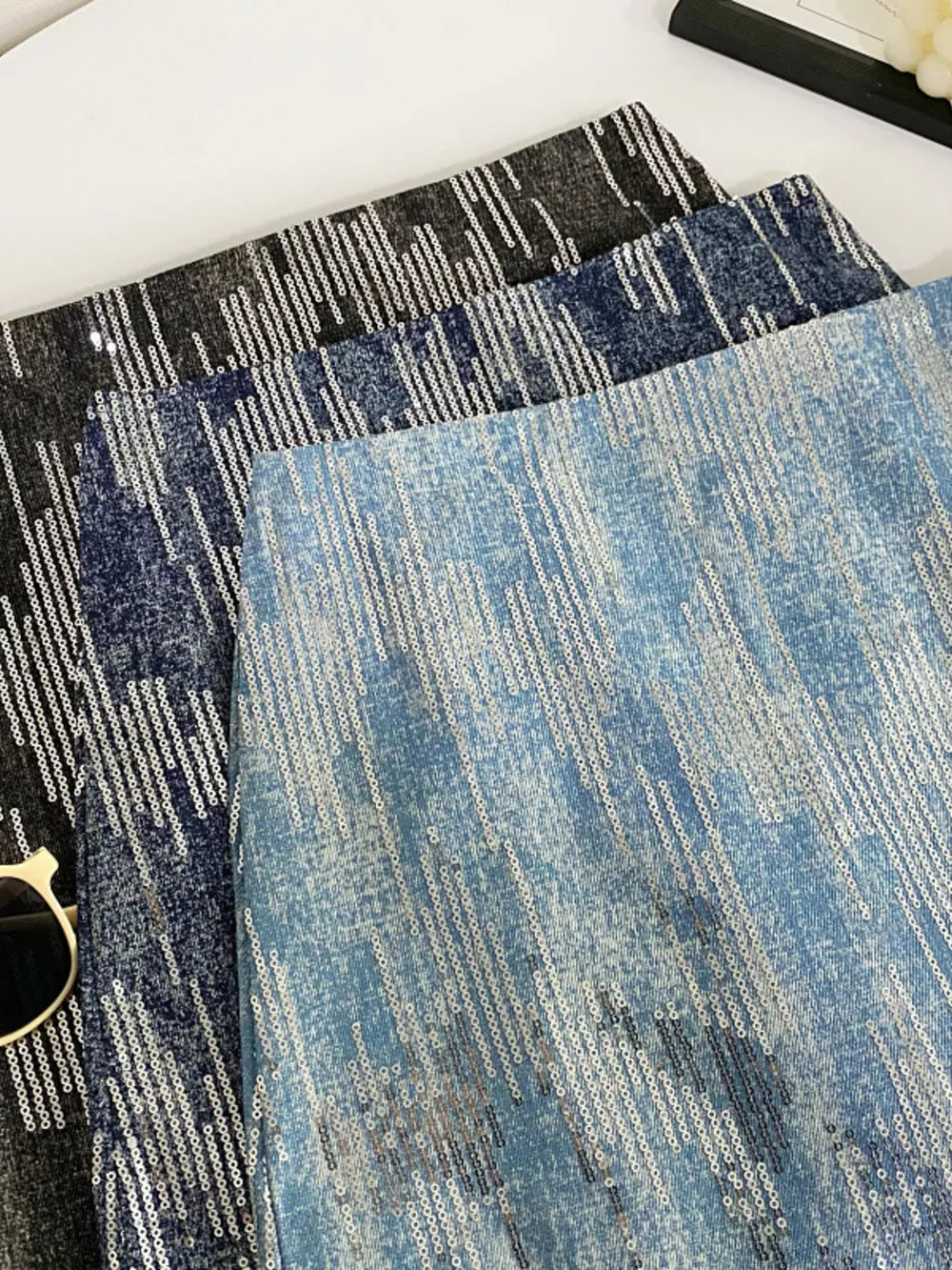 Shimmering sequin mini skirt in light blue, dark blue, and black with diagonal sequin pattern.