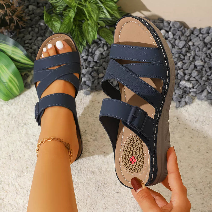 Blue multi-strap wedge sandals with adjustable buckle and criss-cross detail.