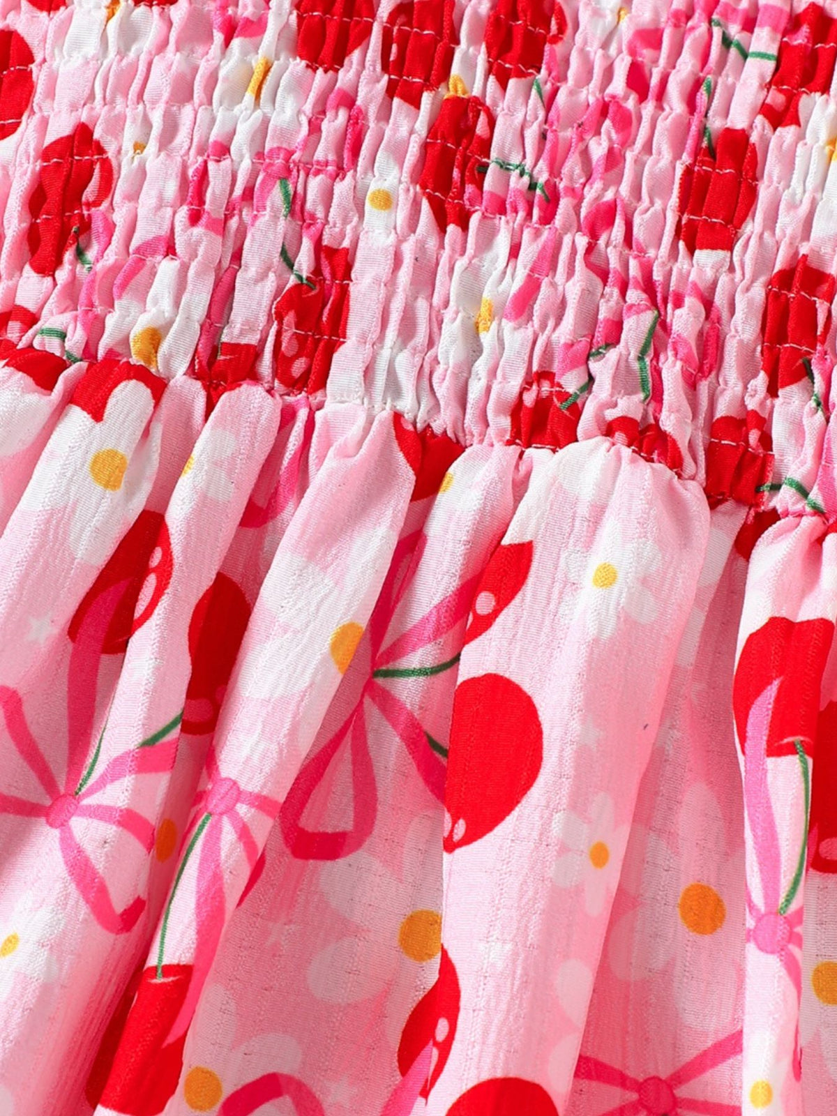 Toddler dress with smocked bodice and pink cherry print fabric.