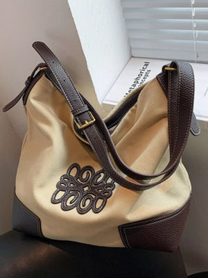 Khaki canvas shopper bag with brown leather trim and embroidered detail