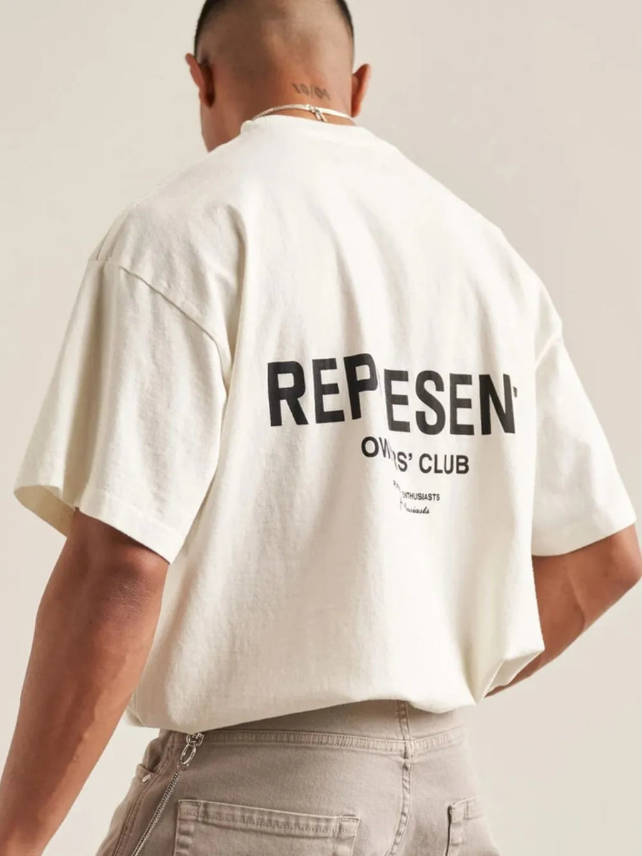 Oversized ivory graphic tee with black "REPESEN OWNERS' CLUB" text on back.