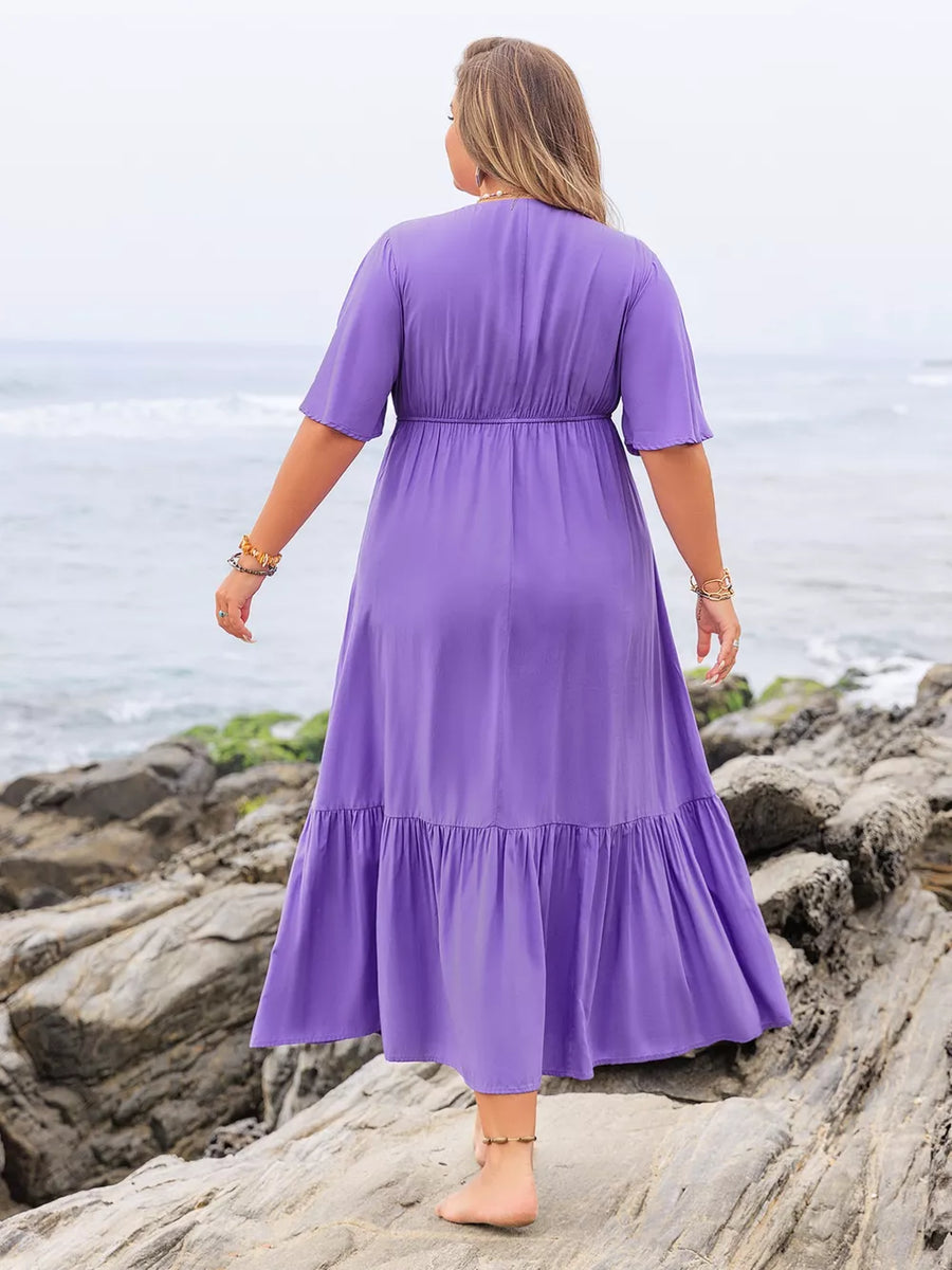Purple V-neck tiered maxi dress with ruched waist and short sleeves, shown from the back.