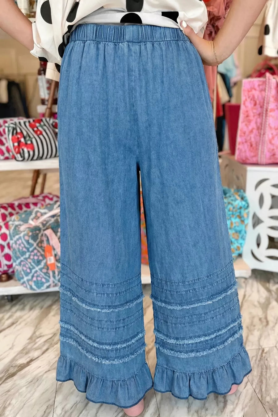 Maternity wide-leg chambray jeans in blue denim with ruffled hem detail.