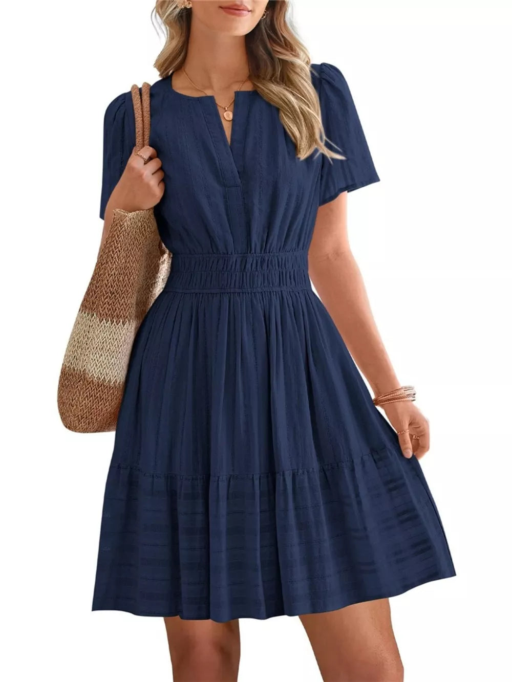 Dark blue textured V-neck tiered dress with smocked waist and short sleeves.