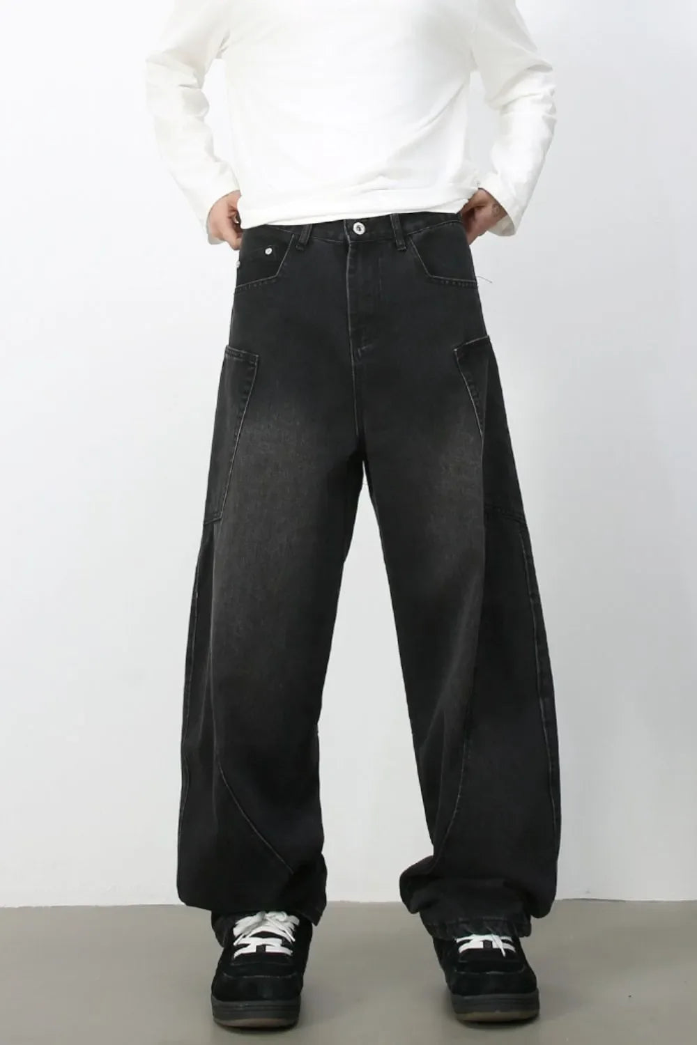 Black denim baggy trousers with a relaxed fit and unique pocket details.