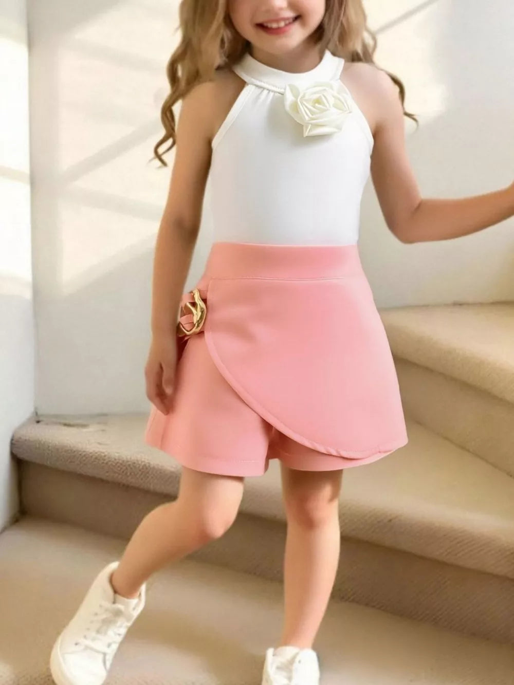 Toddler white halter top with rose applique and pink skort with gold buckle detail.