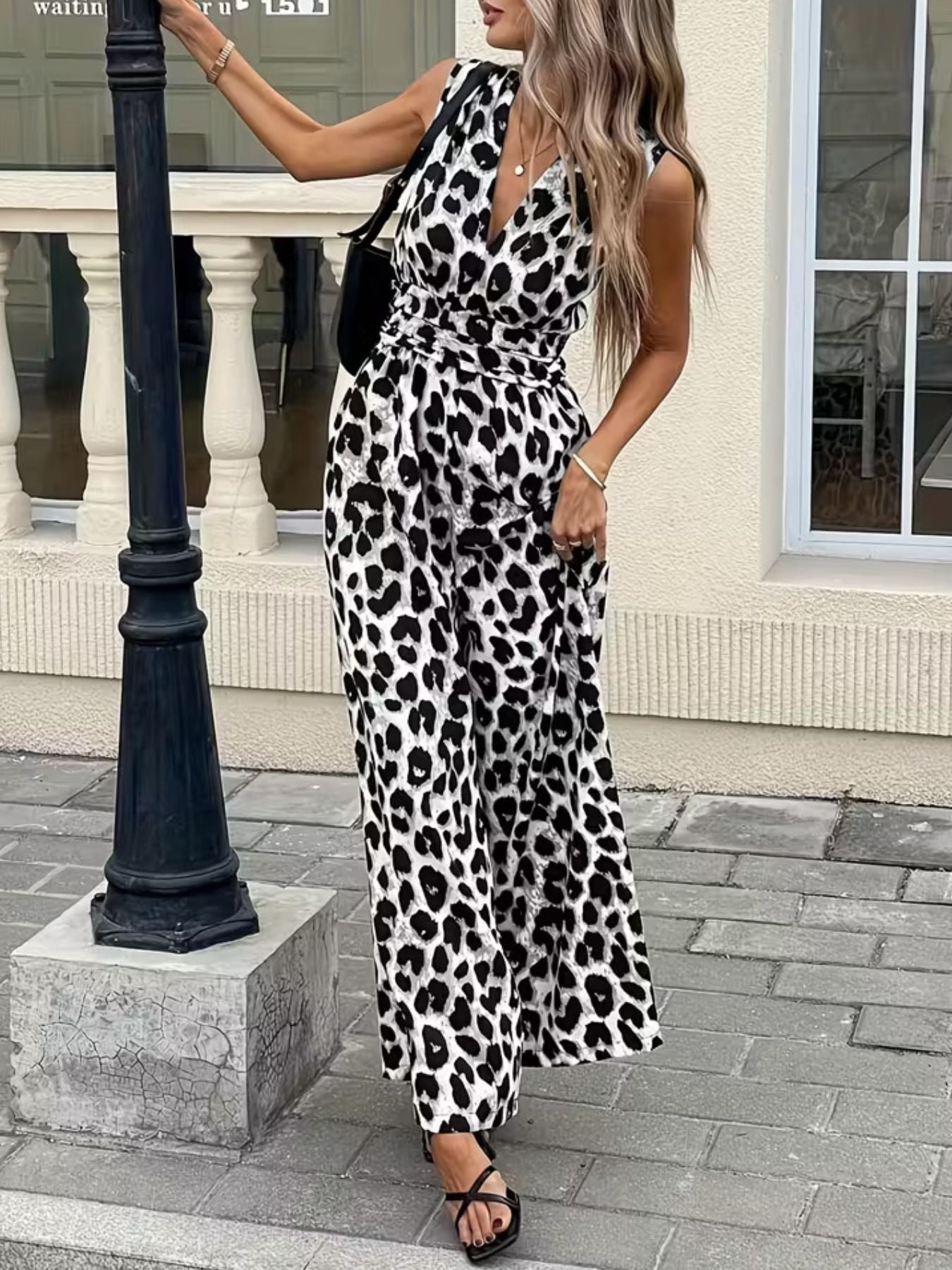 Sleeveless leopard print romper with V-neck and belted waist.