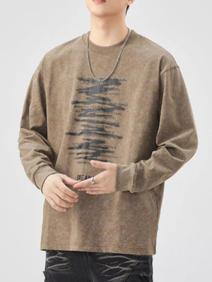 Brown oversized long-sleeve tee with graphic text print and distressed wash.