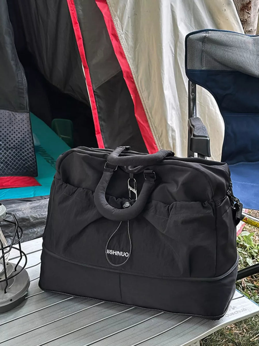 Black crinkled nylon drawstring travel bag with top handles and a detachable strap.