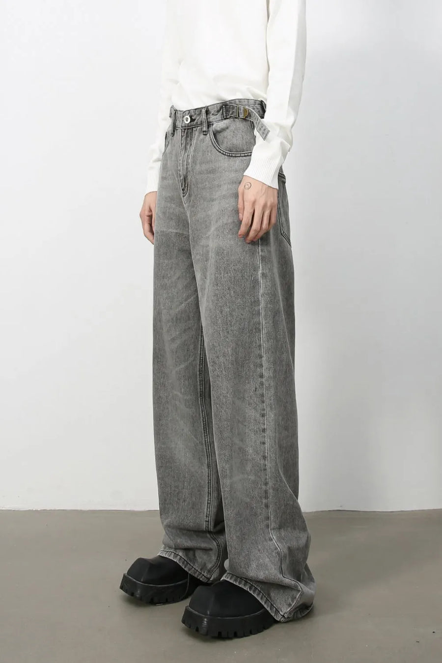 Wide-leg dark gray washed denim jeans with a belt and a relaxed fit.