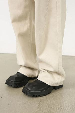 Oversized beige denim jeans with a sculpted leg and neutral wash.