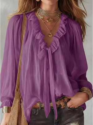 Purple frilled tie-front shirt with long sleeves and ruffled neckline.
