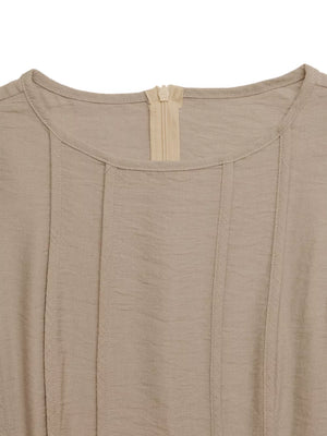 Textured beige maxi dress with elegant silhouette, featuring a round neckline and front zipper detail.