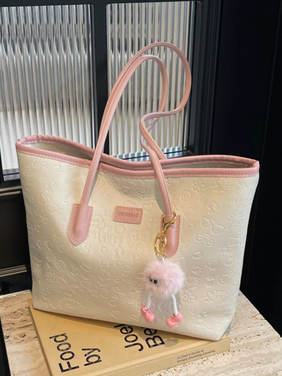 Embossed PU leather tote bag in cream with pink trim and handles, featuring a cute fuzzy charm.
