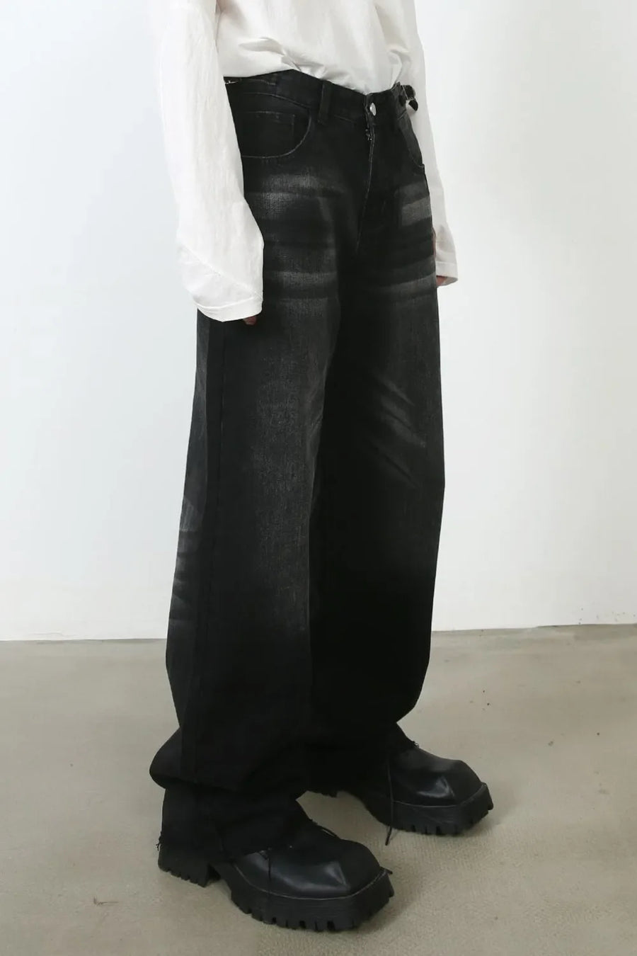 Dark wash denim barrel leg jeans with whiskering detail.