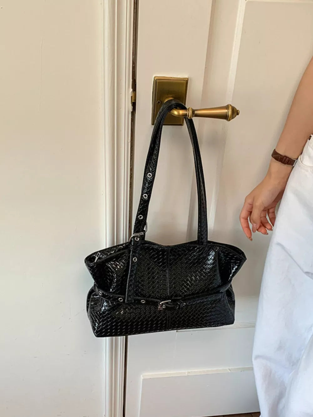 Black shoulder bag featuring woven texture and woven