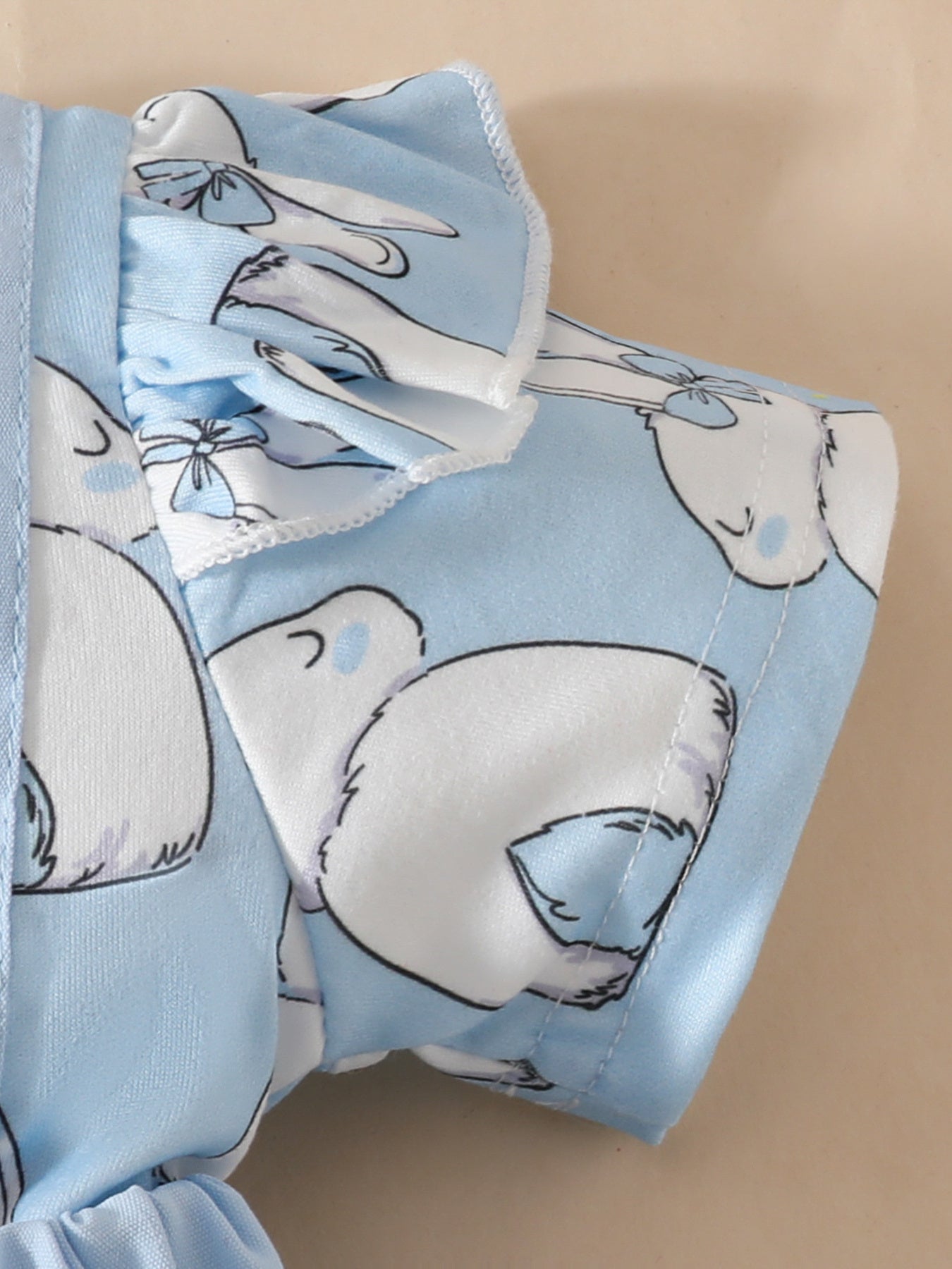 Sky blue baby dress with bunny applique and ruffled sleeves.