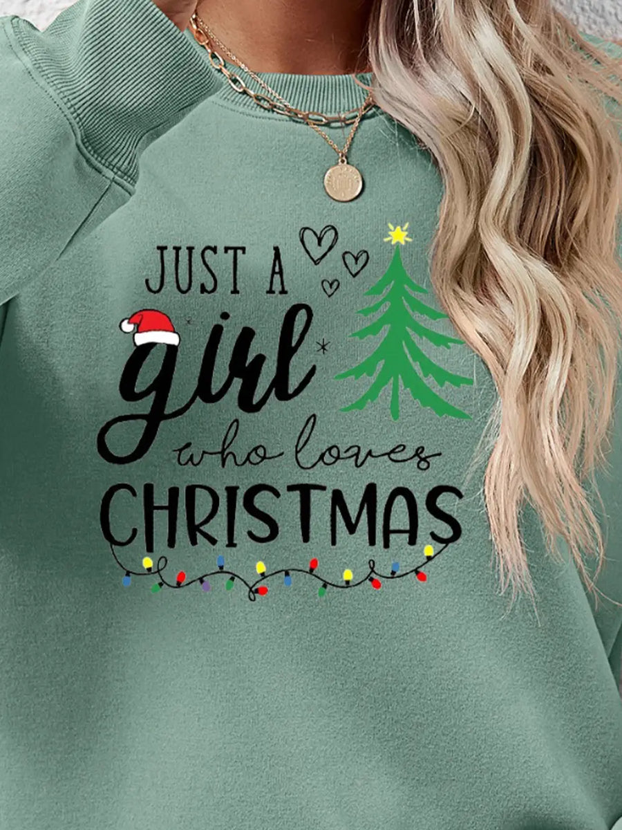 Sage green crewneck sweatshirt with "Just a girl who loves Christmas" graphic and string lights.