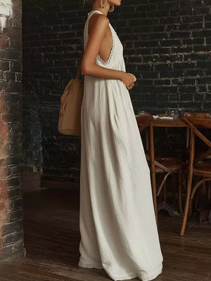 White linen maxi dress with lace trim and a v-neck, sleeveless, flowy fit.