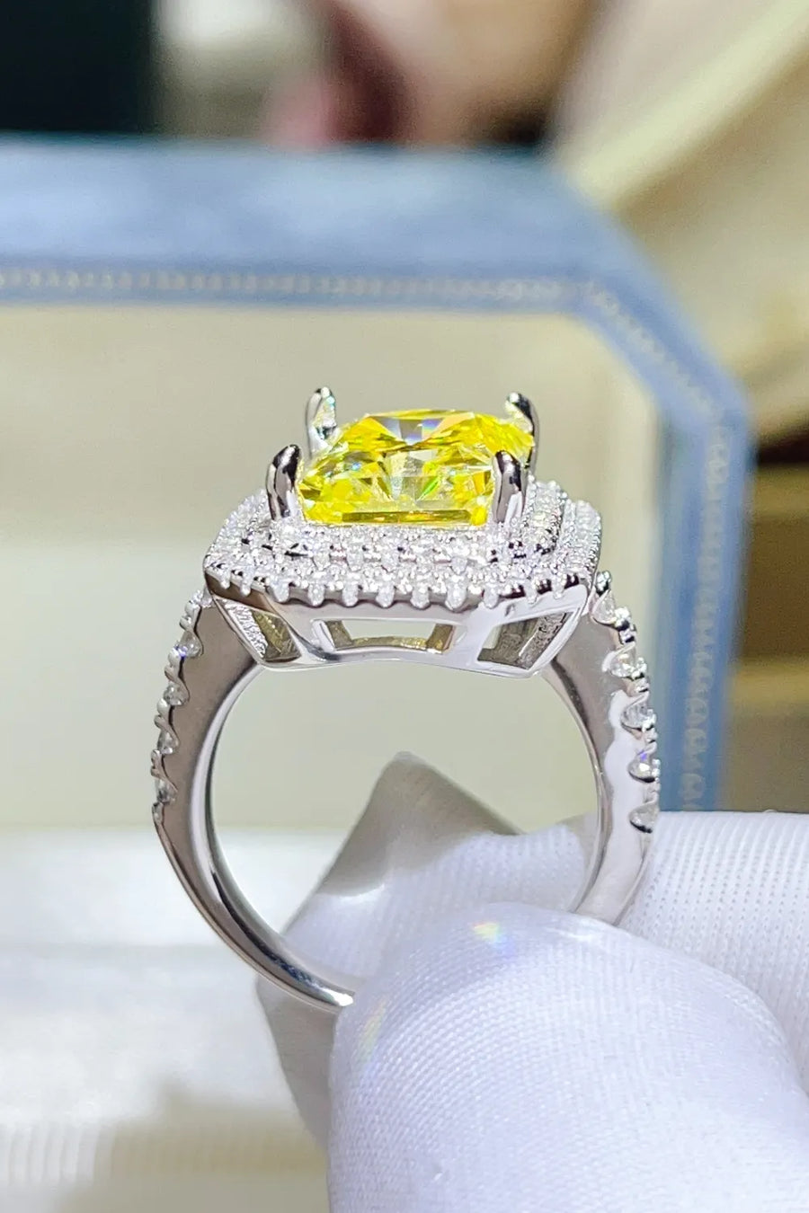 Yellow radiant cut halo ring with canary moissanite and diamond accents.