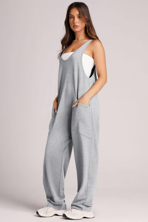 Relaxed fit gray jumpsuit with oversized pockets and a white tank top.