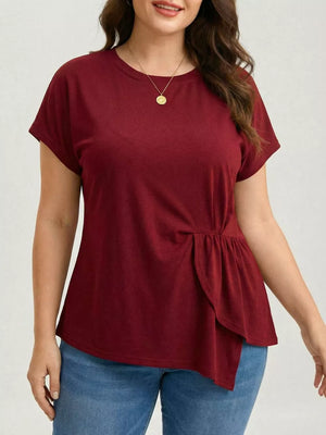 Plus-size burgundy crew neck t-shirt with asymmetrical ruched hem detail.