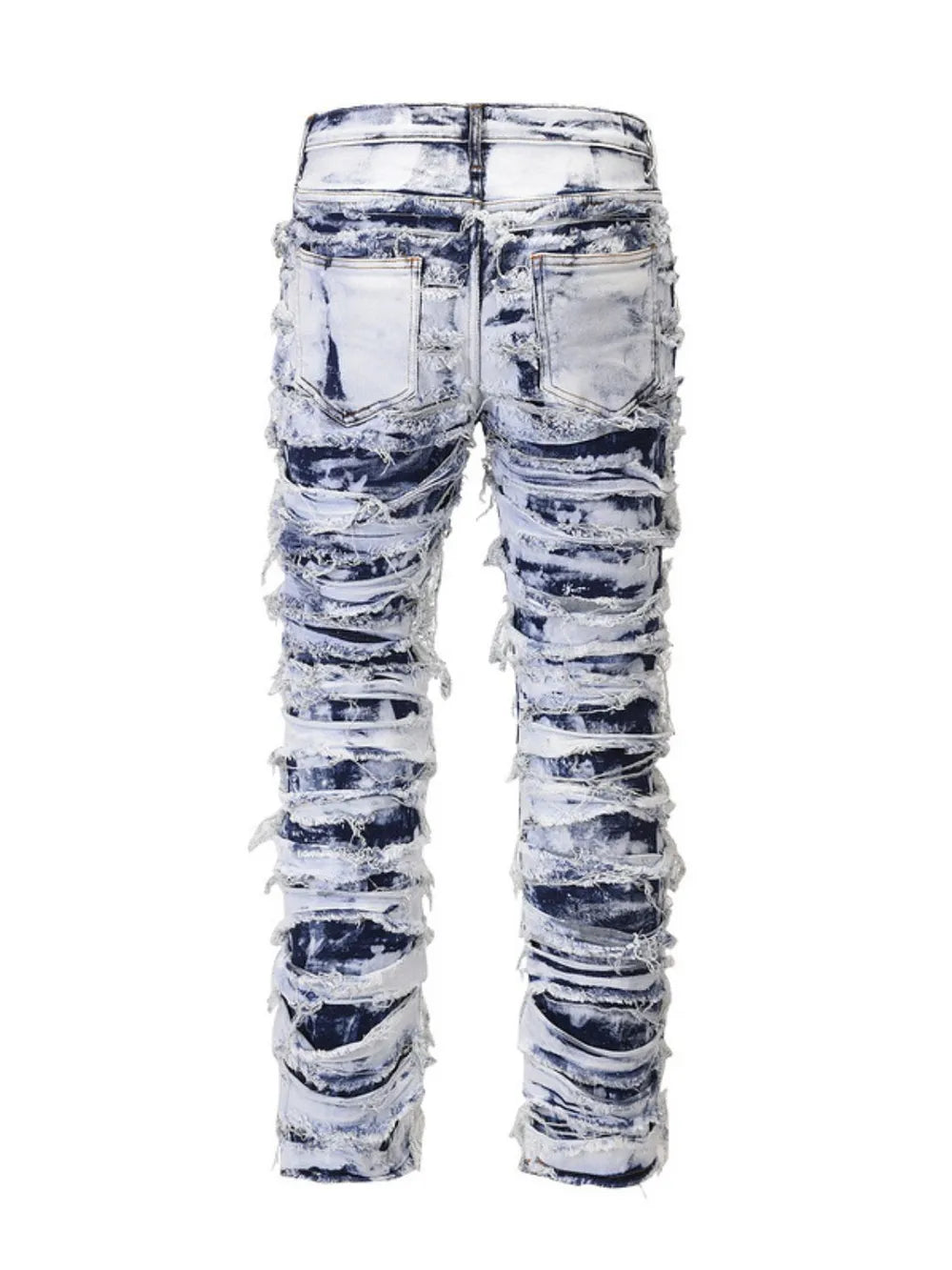 Distressed shredded denim jeans in medium sculptural wash with artistic rips and fraying.