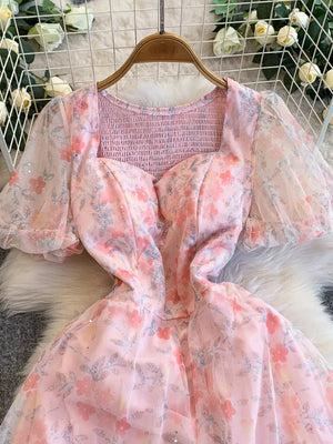 Pink floral sweetheart maxi dress with smocked bodice and sheer puff sleeves.