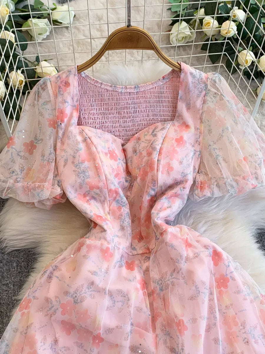 Pink floral sweetheart maxi dress with smocked bodice and sheer puff sleeves.