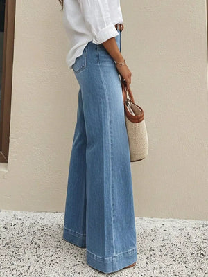 Women's light wash denim wide-leg jeans with pockets and a wide hem.
