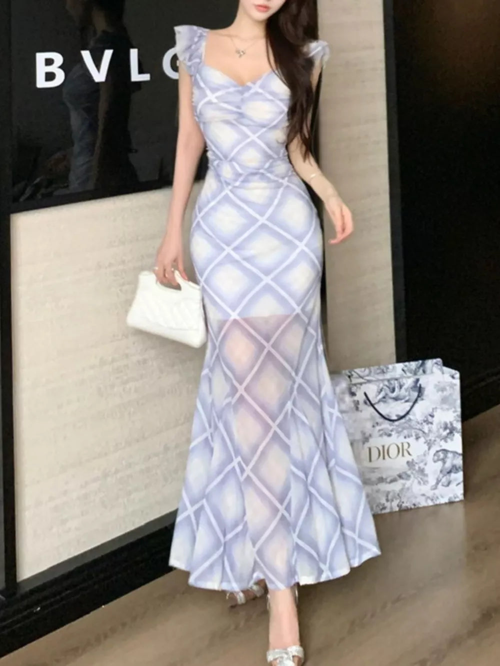 Ruched plaid bodycon maxi dress in blue with sweetheart neckline and sheer skirt.