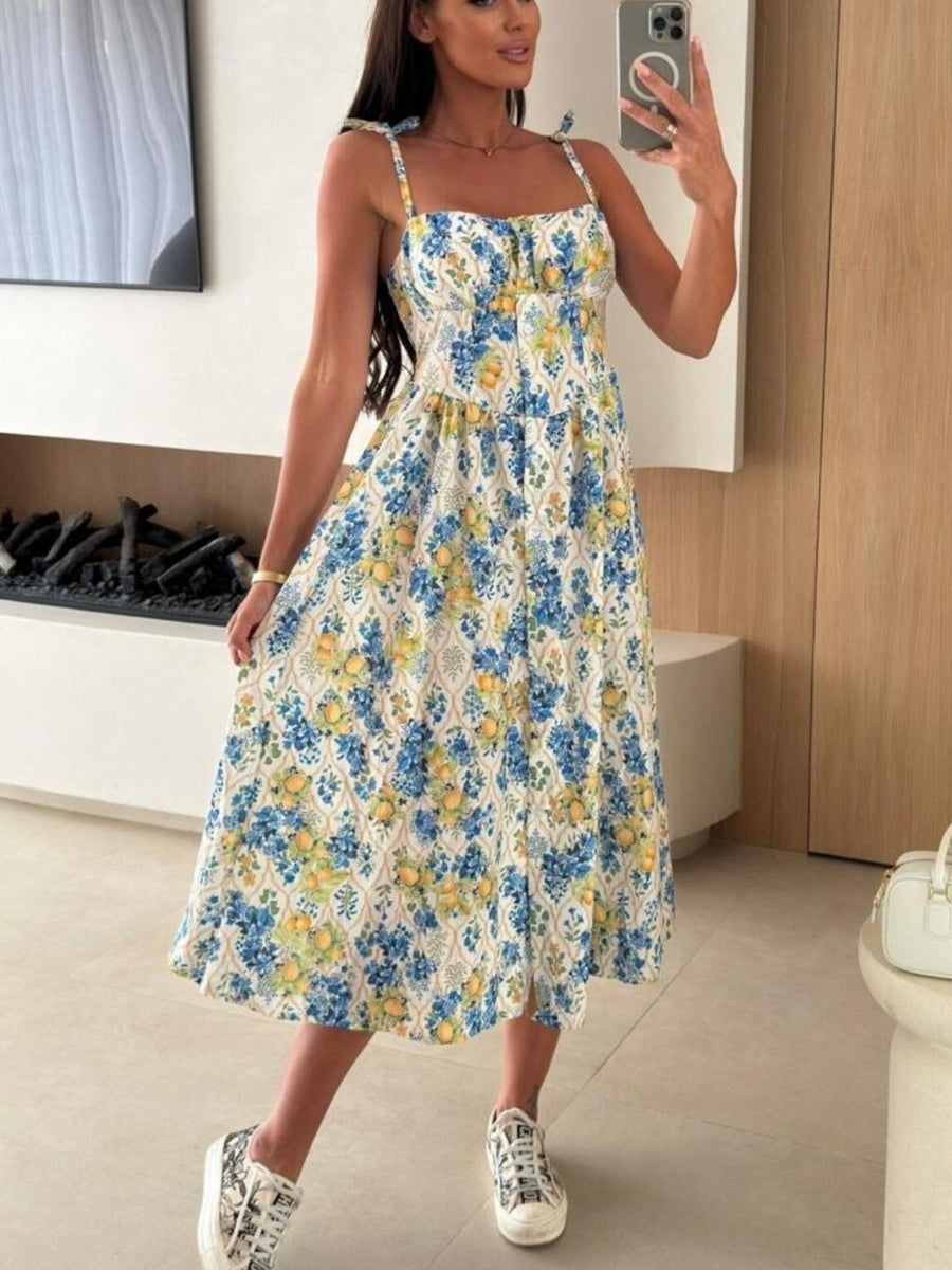 Tie-shoulder midi dress with blue and yellow floral print and adjustable straps.