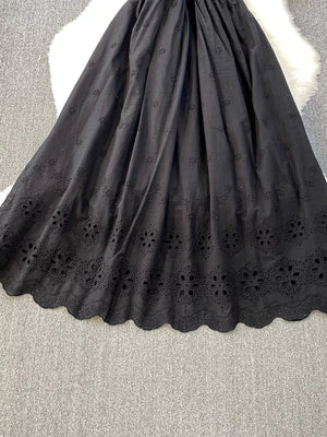 Black eyelet maxi dress with scalloped hem and floral cutout details.
