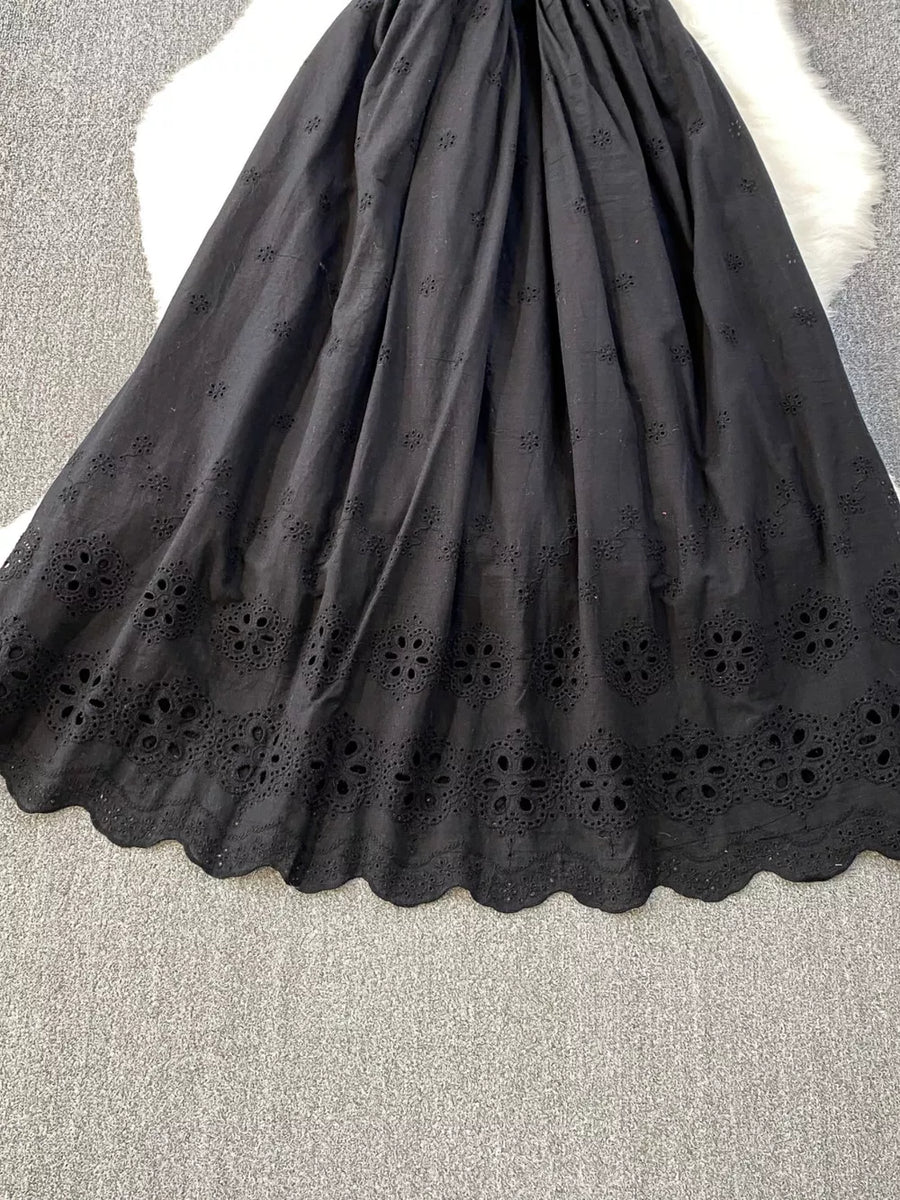 Black eyelet maxi dress with scalloped hem and floral cutout details.