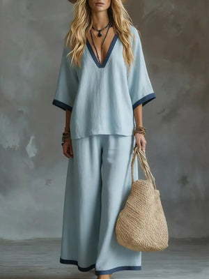 Light blue V-neck two-piece set with contrast trim, wide leg pants and short sleeves.