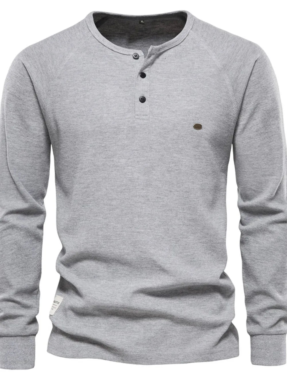 Gray waffle knit henley top with raglan sleeves and button placket.