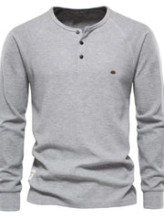 Gray waffle knit henley top with raglan sleeves and button placket.