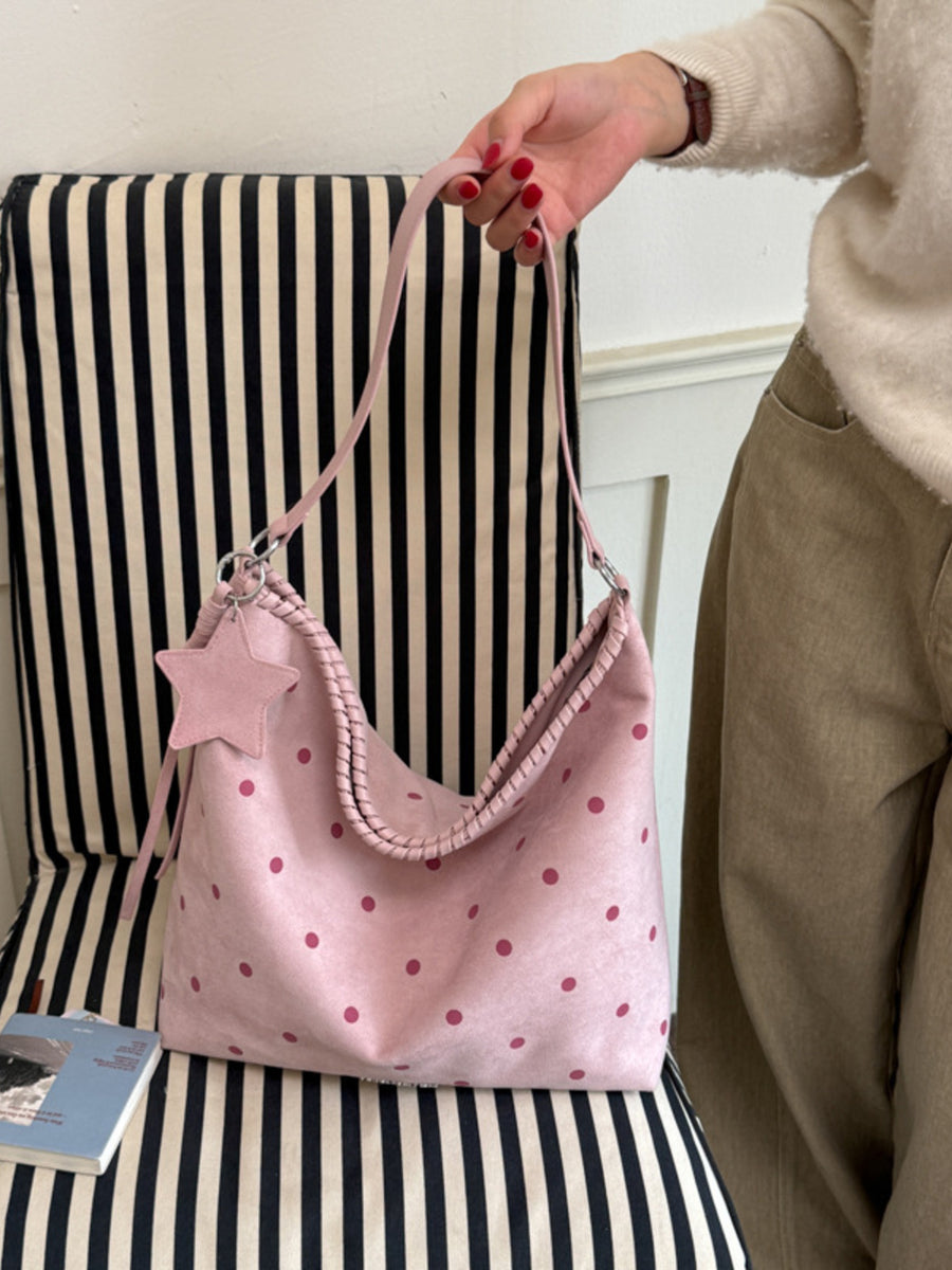 fuchsia handbag featuring shoulder strap and polka dot