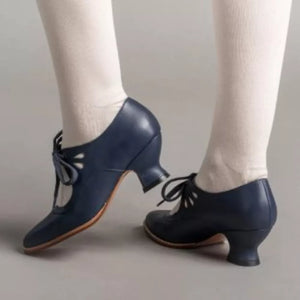 Navy leather t-strap heels with lace-up detail and cut-out accents