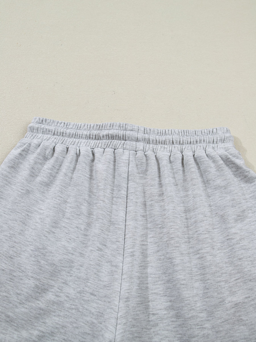 Light grey polyester lounge shorts with elastic waistband and drawstring detail.