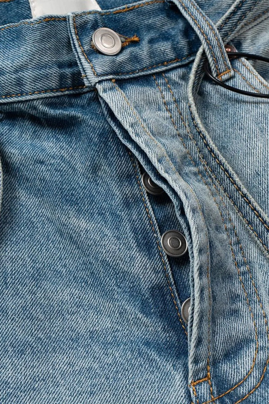 Distressed denim bermuda shorts in medium wash with button fly and tie detail.