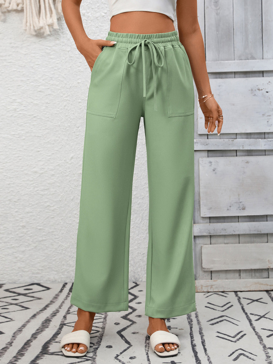 Green drawstring wide-leg pants with elastic waist and patch pockets.