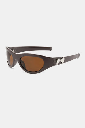 Brown sporty shield sunglasses with silver bow embellishment and brown lenses.