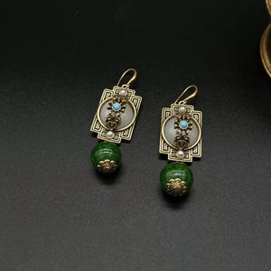 Vintage gold-plated dangle earrings with dark green beads and ornate detailing.