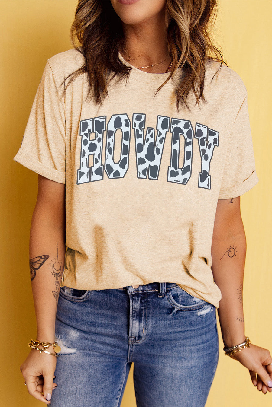 Light apricot t-shirt with cow print "Howdy" graphic and rolled sleeves.