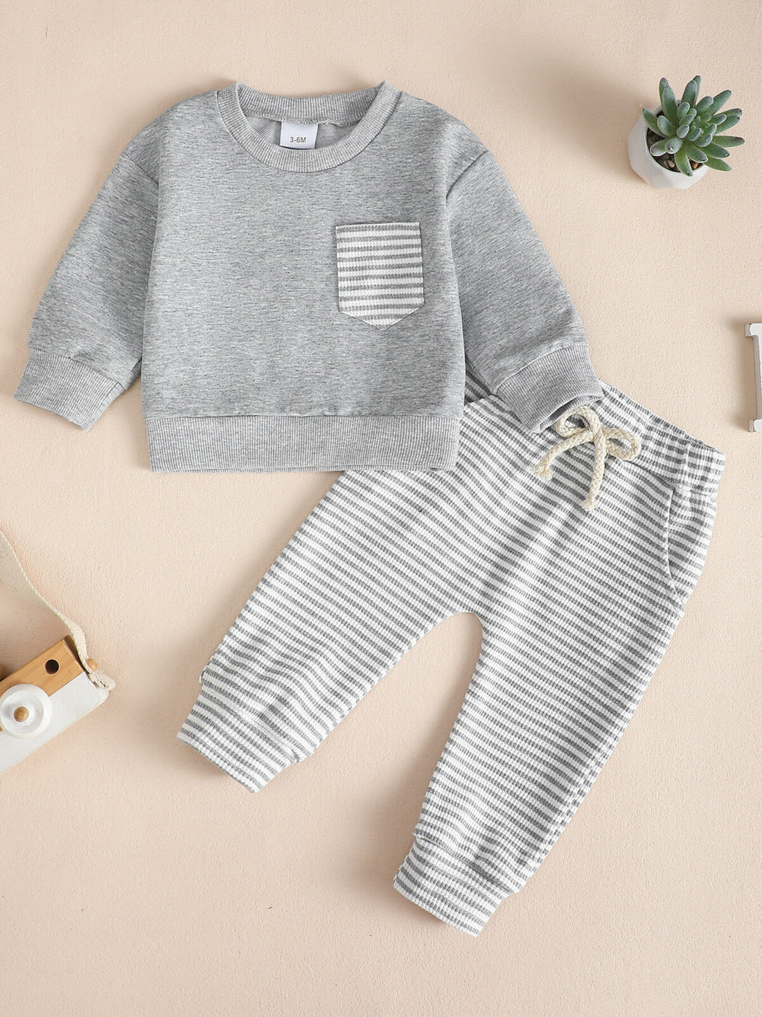 Children's grey cotton sweatshirt with striped pocket and matching striped pants with drawstring.