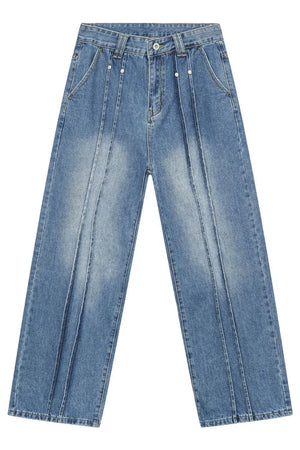 Medium wash denim trousers with vertical seams and a relaxed fit.