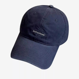Navy baseball cap with embroidered "barcelona" text and stitched brim.