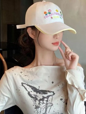 White cotton baseball hat with floral embroidery and yellow brim detail