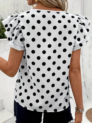 White polka dot blouse with ruffled short sleeves and a round neckline.